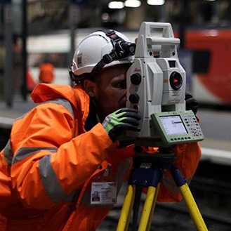 A surveyor measuring with Leica TS60 on railway station